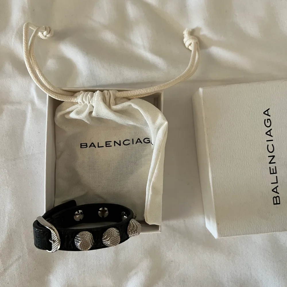 Balenciaga armband i svart med silverdetaljer. Armbandet är i perfekt skick. . Accessoarer.