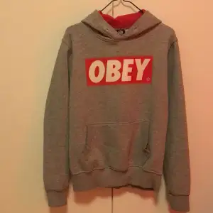 Grå obey hoodie storlek L med röd luva 