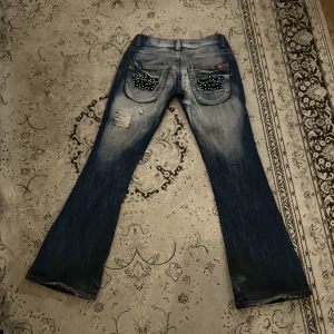 Lågmidjade bootcut jeans  - Superfina lågmidjade bootcut jeans! Märke Bluee queen. Midjemått: 78 cm Innerbenslängd: 80 cm. Lite slitna längst ner men utöver det inga defekter. För mer info eller bilder är det bara att skriva privat💋