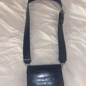 Väska - Säljer min sjukt snygga väska från Åhléns för att det inte kommer till någon användning längre. Det finns två band till väskan och ett stort fack i väskan och två små. Väskan är som ny skick.(Ny pris 499kr)Skriv för fler frågor osv(tryck inte på köp nu).💕