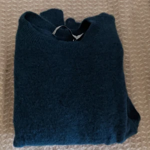 & other stories tröja - 33% ull 33% mohair 33% polyamid Svårt att fånga färgen på bild men det är en blågrön ton 