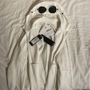 CP Company diagonal goggle sweatshirt - CP Company diagonal raised fleece goggle sweatshirt/ziped hoodie(M)(vit) Nypris:2700kr Köpt från hemsida) Väldigt bra skick. Tags medföljer