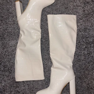 Stövlar med klack - Beiga (fake) skinnklackar med ormmönster. Aldrig använda pga fel storlek. Runt 10 cm höga! 