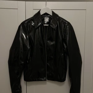 Lackjacka (HM x EYTYS)  - Svart lackjacka från H&M x Eytys, kort modell. Strl XXS men passar en XS/S. Endast använd ett fåtal gånger. Möjlighet att mötas upp i innerstan.