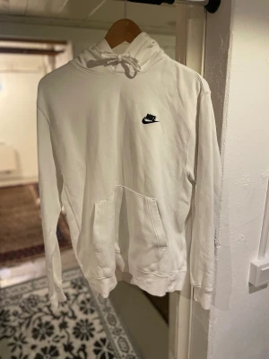 Nike hoodie  - Vit Nike hoodie köpt på Junkyard i storlek small  Tröjan är använd och har 2 svarta fläckar på vänster arm (se bild 3) men utöver det är den i bra skick 