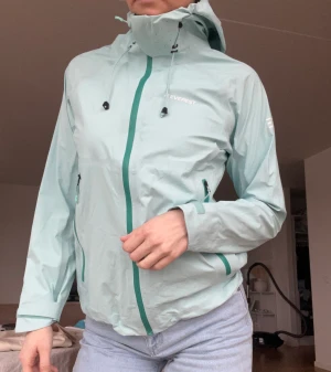 Regnjacka med tejpade sömmar - Regnjacka från Everest Sparsamt använd.  Bild 2 och 3 mer rättvis i färg. Turkos. Tejpade sömmar=vattentät Storlek 38, aningen liten om man vill ha mycket under.