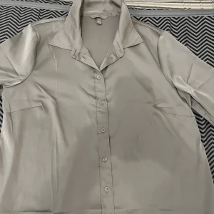  Skjorta  - Fin satin skjorta som har används ett få tal gånger. Skjortan är köpt från hm den är ganska skön och snygg.