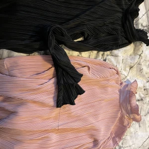 Blus/tröjor - 2st Blus/Tröjor med lång ärm. Volang i ärmslut. En svart en gammelrosa. Obetydligt använda. Strl. XS