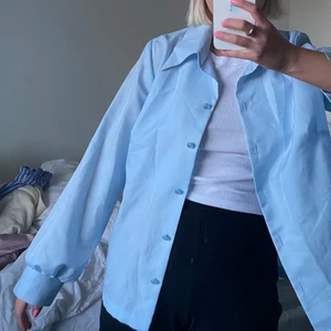 Ljusblå blus - Ljusblå vintage blus som är fin att bära uppknäppt och knäppt. Perfekt färg till våren och sommaren! Storlek är ej märkt, men jag på bilden har vanligtvis storlek S och bär den smått oversized.
