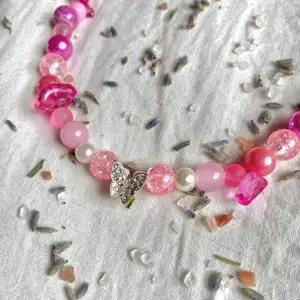 Superfint y2k halsband med en fjärilsberlock och mixade rosa pärlor🤍
