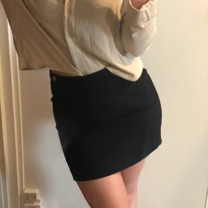 Svart minikjol - Knappt använd svart minikjol med två guldknappar. Frakt ingår 🐬🐬🐬