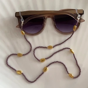 Glasögonkedja snäckor  - Handgjord glasögonkedja med snäckor, 66 cm lång. Köparen står för frakten 13kr. Kolla gärna mina andra annonser, samfraktar. 