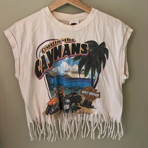 Avklippt hippie t-shirt - Unik avklippt t-shirt med fransar. Olika tryck på fram- och baksida. Tjockt bomullstyg. Går till naveln på mig som är 170 cm. 