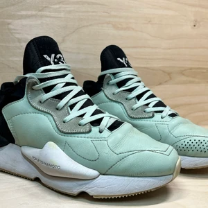 Y-3 Adidas, Kaiwa, gröna, strl 40 2/3 - Sneakers från Y-3 och Yohji Yamamotos samarbete med Adidas. Modellen Kaiwa, ljusgröna med svarta och vita detaljer. Skorna är välanvända men alltid välskötta. Lädret har några mindre skador och sulorna är något grådassiga samt har en liten gul missfärgning på högra skon. Nya ljusgröna snören medföljer. Storlek: 40 2/3. Nypris: 3500 kr (sommaren 2019). Skick: Helt ok. Dustbag: Ja. Kartong: Nej. Material: Läder/textil. Sula: Gummi.