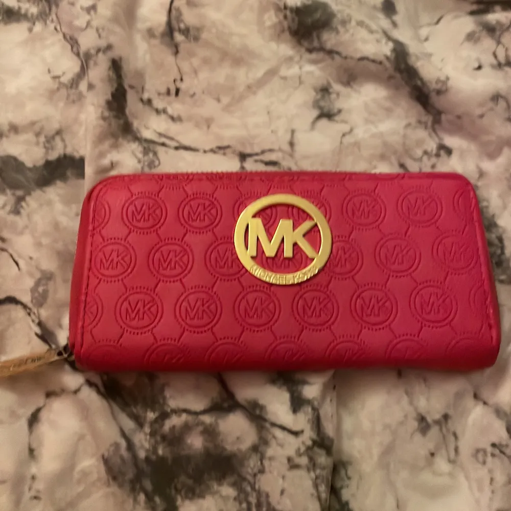 En snygg Mk plånbok (inte äkta) ganska använd men fortfarande snygg😊😊😊. Väskor.
