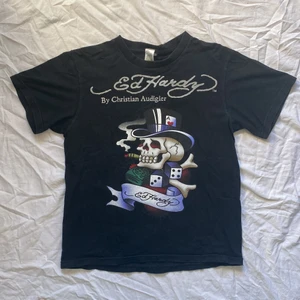 Ed hardy t-shirt - ⭐️KOLLA IN MIN PROFIL FÖR FLER ED HARDY T-SHIRTS!! ⭐️ Cool t-shirt från ed hardy med tryck och silver glittrig text. Storlek oklar men uppskattas till en M, så passar XS/S/M beroende på önskad passform. Köparen står för frakt. ⭐️