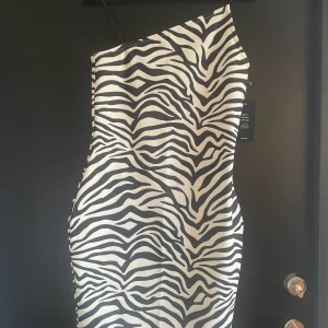 Klänning - Tight Klänning i zebramönster. Aldrig använd, lapparna kvar. Säljer pga för stor (stor i storleken)