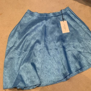 Kjol från NaKd - Blå kjol från NaKd i storlek M. Är lite längre kjol så slutar lite efter knäna.