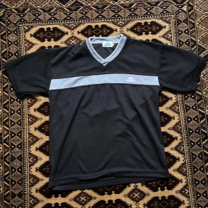 Adidas vintage  - En vintage adidas tshirt i mjukt material. 100% cotton. Lite nopprig men den e vintage. Längd ca 65-66 cm. Armhåla till armhåla ca 53 cm. Sitter mer som M än L