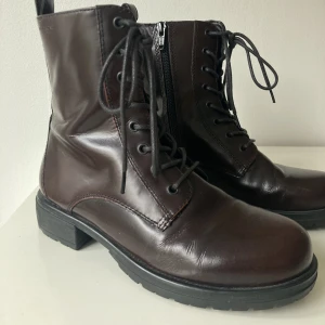 VAGABOND | storlek 36 - Vinröda Boots från Vagabond i storlek 36. Med snörning fram och dragkedja i sidan. Extremt sparsamt använda, men tyvärr lyckats få en liten repa vid högra framsidan (se sista bild). Nypris 1200kr. ✨ Frakt tillkommer. 