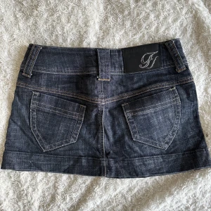 Formula jeans kjol - Lågmidjad jeanskjol från formula jeans. Snygg mörk tvätt med bruna sömmar. I storlek 38 men passar mig bra som brukar ha 36💗