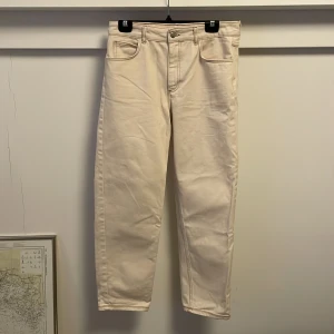 Jeans reclaimed vintage - Offwhite jeans med bruna sömmar. Lite pösigare än taper fit. Använda ett tiotal gånger. Bra skick. En liten fläck på vänster knä som jag inte gett någon vidare energi till att få bort. Lite liten i storleken.