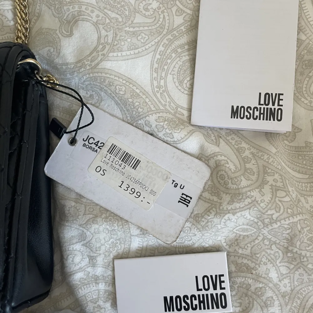 Love moschino väska i nyskick. Prislapp finns kvar på väskan och dustbag medföljer. Perfekt storlek där man får plats med allt man behöver. Köpt för 1399kr. Skriv privat för fler bilder, mått på väskan mm. . Väskor.