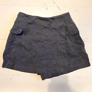 Svarta skort / tenniskjol - Superfin svart skort (shorts+skirt)  som tyvärr inte passar mig längre🦇 Den är svart men första bilden är ljusare för att man ska kunna se detaljerna. Två sidofickor & mellanhög midja. Midjemåttet är 62cm. Verkligen jättefint plagg som passar många stilar