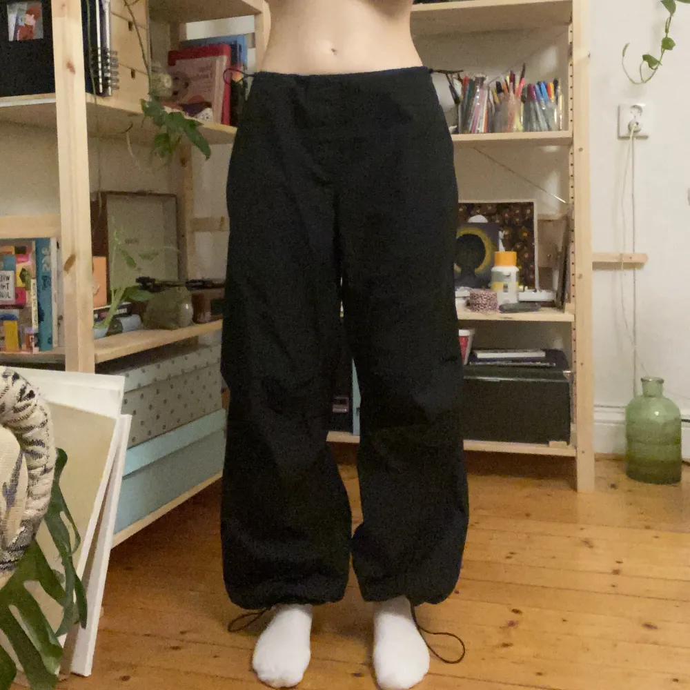 Svarta parachute pants från pull&bear, använda en gång. Storlek M men små i storleken.. Jeans & Byxor.