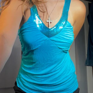 Halternecktopp - Detta är en blå halternecktopp med en snygg glitter detalj vid bröstet, jag har två likadana så väljer att sälja en🌸 Storlek: S/M 