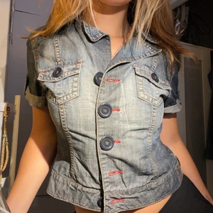 Denim tröja - En snygg kofta/ tröja gjord i jeans material, som man ser på bilden har den knappar så man kan ha den öppen och stängd! Den går nästan ner till höften men har en croppad design