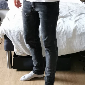 Svarta/Mörkgråa jeans slim fit - Rebel jeans i bra skick. Slim fit. Lite slitage på vänstra byxbenet men det ser naturligt ut och gör byxorna snyggare enligt min mening. Jag är 187 cm lång. Tveka inte att skriva om ni har frågor. 