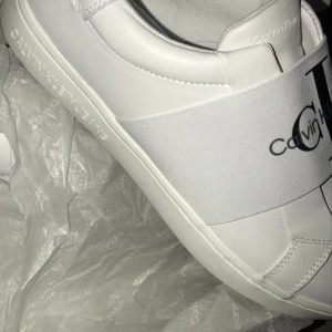 Calvin Klein Jeans Skor - Ett par helt oanvända vita Calvin Klein Skor. Säljer pga de är för stora!