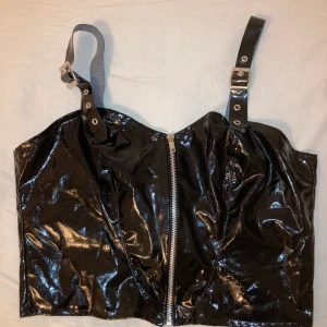 Latex korsett - Snygg latexkorsett/ latextopp med dragkedja fram. Passar över de flesta outfits för att ge en najs touch/ att bara ha som den är utan något under. Jag är en storlek s och den är något löst sittande på mig. Så förslagsvis storlek M!
