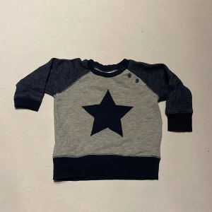 Tröja med stjärna  - En tröja i stl 74. Super fin med stjärna på magen.  Köparen står för frakten. Jag ansvarar inte för postens hantering. Jag visar bild på när jag skickar paketet. Vid fler intressen av objekt kan bud över begärt ingångspris bli aktuellt! 