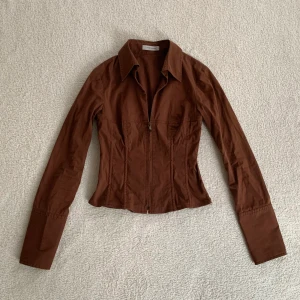 Brun skjorta - Så snygg figursydd korsett-aktig skjorta/topp med dragkedja framtill, från märket René Lezard! Passar mig som brukar ha XS/S 🤎