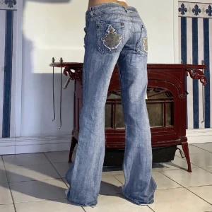 Lågmidjade jeans med tryck där bak! - Är ca 170 och har strl S och de sitter bra på mig. Midja 86cm, innerben 82 & är i fint skick, köptes för 600kr här på plick💕