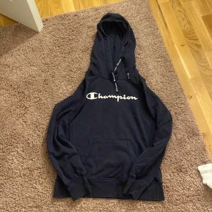 Champion hoddie  - En marinblå champion hoddie i storlek XL (barn)