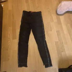 Nya guess jeans står guess på yttersta sidan av benen, lite grå svarta byxor typ 