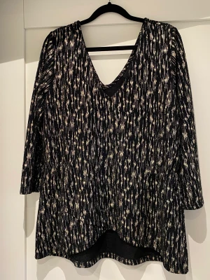 Glittrig topp  - Guldglittrig topp från Object. Lite kortare fram och ganska figursydd modell. Använd men i gott skick, perfekt till nyårsfesten. 