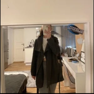 Grå kappa  - En kort grå kappa från Bikbok i storlek Small. Använd 3 gånger men ena öglan till skärpet har gått sönder men går säkert laga lätt med lite nål och tråd bara.  Kan få bättre bilder vid intresse