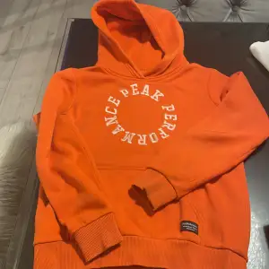 Peak performance orange hoodie i storlek 150 