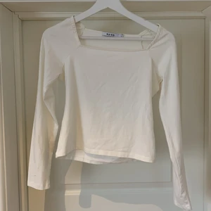 Långärmad topp från NA-KD - Vit långärmad topp i storlek L. Dock en tight modell och upplevs mindre än en L. Märket är NA-KD. Sitter på plats med hjälp av gummiremsa vid ringningen. Väldigt bra skick.