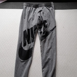 Nike träningsbyxor - Nike tränings byxor knappt använda. St står i lappen. Gråa byxor med svart nike tryck. 146-156 12-13 år. Har använt dem sj å är 14. 