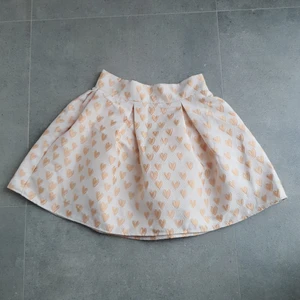 Retro kjol Chicwish guld hjärtan stl M - Söt utsvängd kjol med veck. Fodrad och dragkedja i sidan.Knappt använd. Mäter 72 cm i midjan och 48 cm lång. 