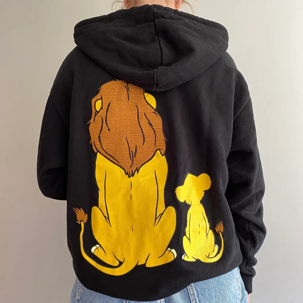 En svart hoodie med lejonkungen motiv på ryggen. Den har inga fickor. Använd 1-2 gånger. Du står själv för frakten💕. Hoodies.