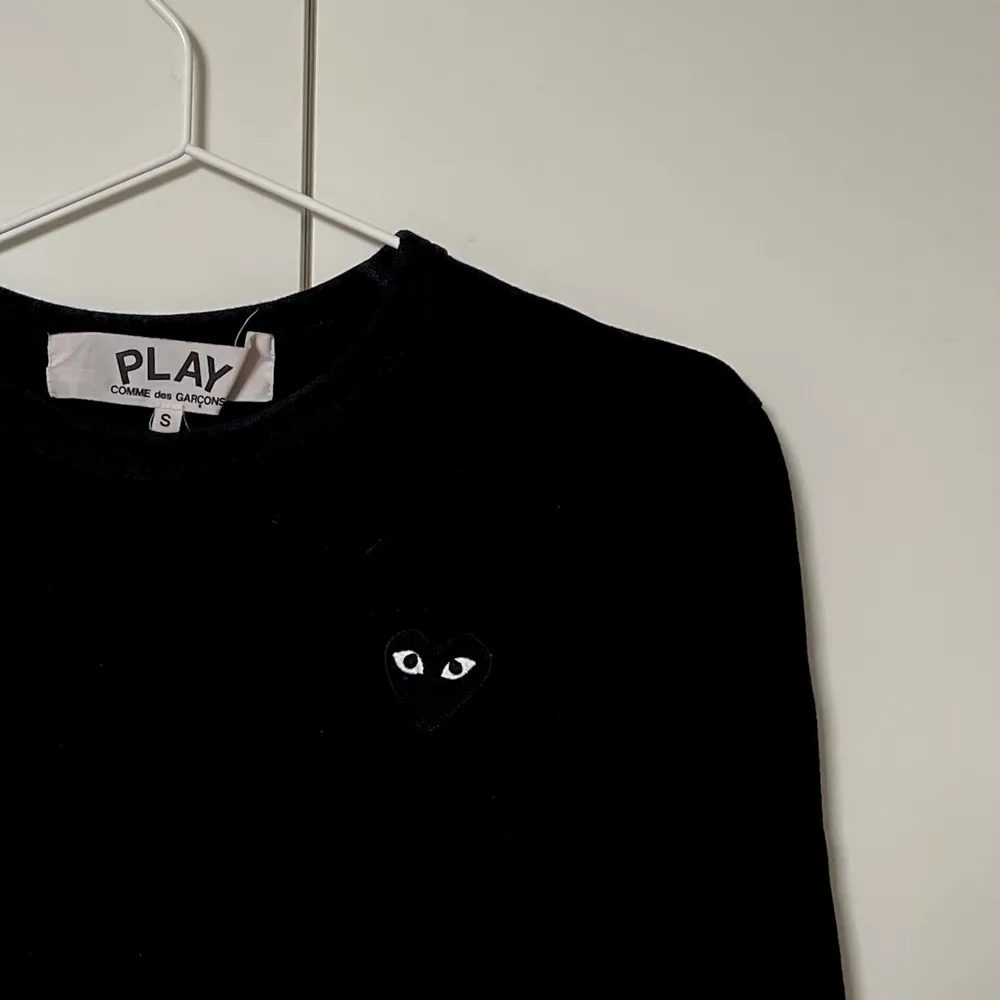 En svart, långärmad t-shirt från CDG Play i storlek S. Gott skick 🖤  Kan skickas med spårbart paket via PostNord eller mötas upp i Stockholm!. T-shirts.