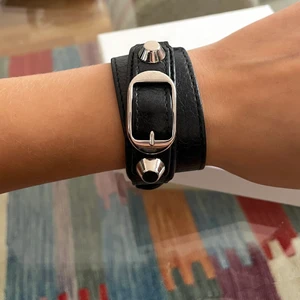 Balenciaga Armband i svart läder & silverdetaljer - Säljer mitt fina Balenciaga armband i svart läder med silverdetaljer, storlek S. Finns tre hål för att justera storleken.  Kommer med låda, dustbag och äkthetsmarkering. Använt men i gott skick.   Kan mötas upp i Stockholm 💓