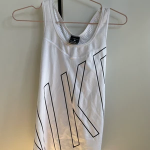 Nike träningslinne - Vitt träningslinne från nike. Superfint men kommer tyvärr inte till användning längre. Storlek xs men passar s och m också då det är stretachigt