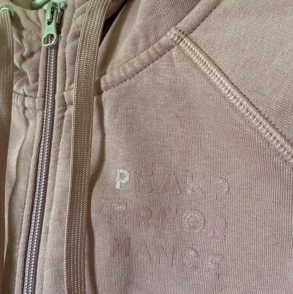 En rosa Peak performance zip- up hoodie. Nytt skick. Värde ca 500kr.. Neuletakit & Villapaidat.